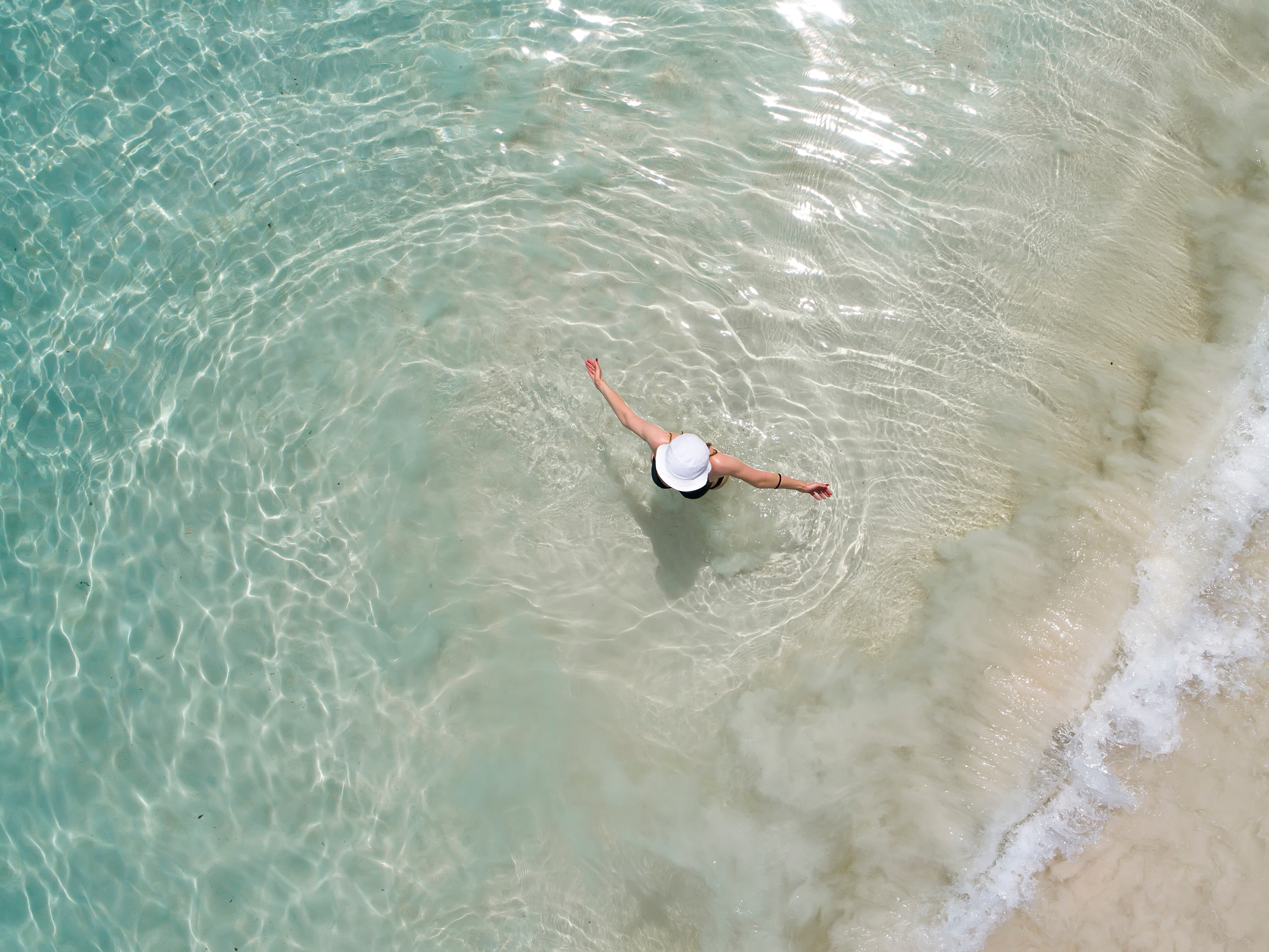 Vogelansicht einer Person im Meer