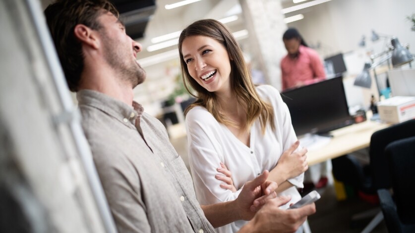 Two colleagues laugh together