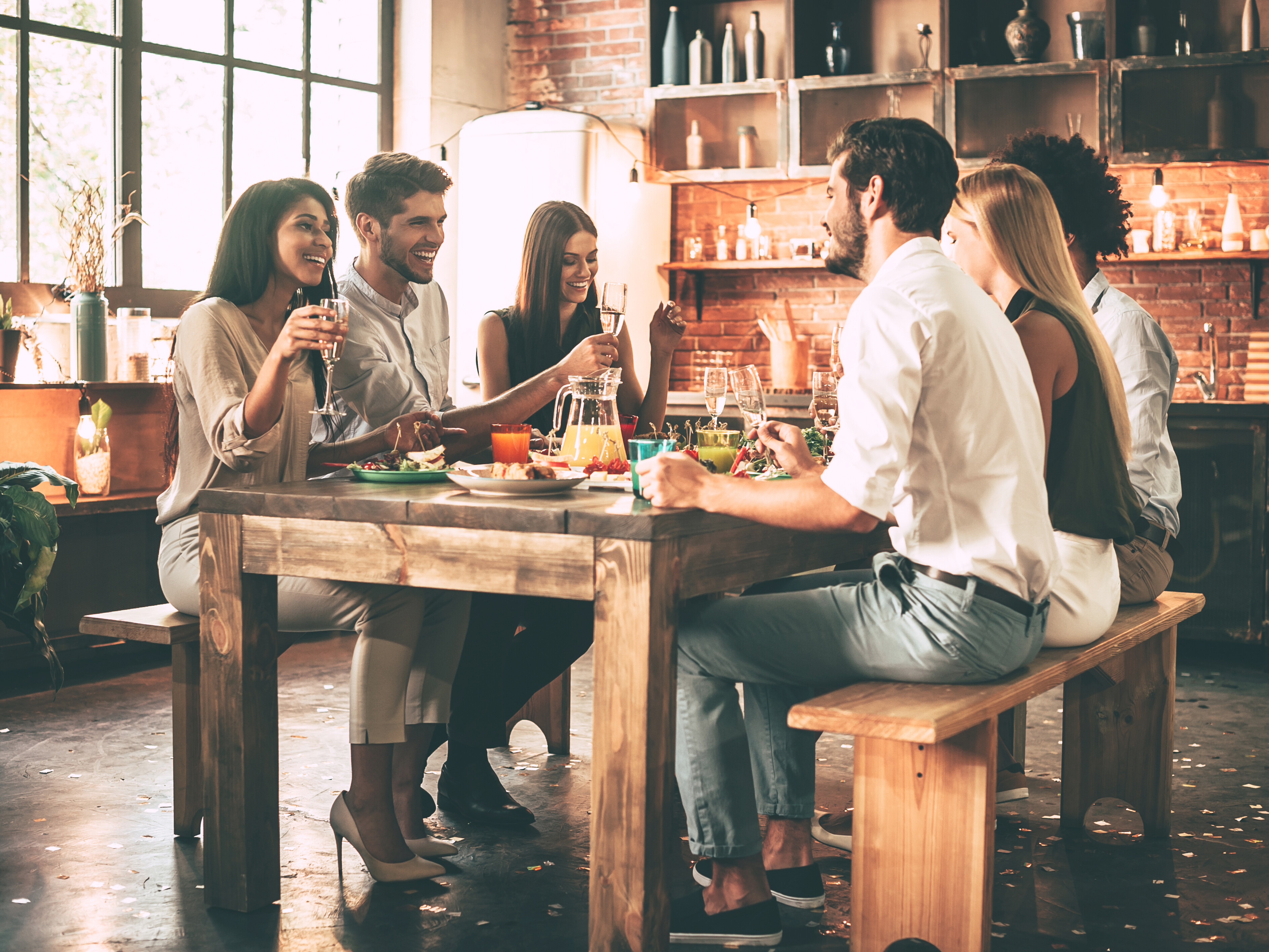 Glückliche Menschen, die an einem Tisch sitzen und essen